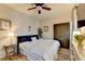 Cozy bedroom with a large bed, ceiling fan, small side table, and a large closet with panel doors at 5890 Bond St, Cumming, GA 30040