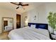 Well-lit bedroom with a large bed, wood floors, mirror, and a decorative houseplant at 5890 Bond St, Cumming, GA 30040