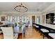 Open-concept dining room and kitchen with a wine cooler, hardwood floors, and a large table for eight people at 5890 Bond St, Cumming, GA 30040