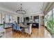 Elegant dining room and kitchen with a chandelier, hardwood floors, and seating for eight, perfect for hosting dinner parties at 5890 Bond St, Cumming, GA 30040