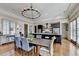 Elegant dining room and kitchen with a chandelier, hardwood floors, and seating for eight, perfect for hosting dinner parties at 5890 Bond St, Cumming, GA 30040