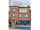 A well-maintained brick townhome with symmetrical design, blue shutters, and attached two-car garage at 5890 Bond St, Cumming, GA 30040