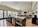 Open-concept kitchen with large island, stainless steel appliances, and hardwood flooring at 5890 Bond St, Cumming, GA 30040