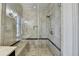 Glass enclosed walk-in shower featuring tiled walls and shower bench with hand held shower faucet at 5890 Bond St, Cumming, GA 30040