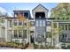 Stylish 3 story townhome with gray and white exterior, multiple balconies, and landscaping at 120 Ridgely Ct, Atlanta, GA 30342