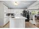 White kitchen cabinets, tile countertops, and an island with a cooktop at 3228 Rosebud Rd, Loganville, GA 30052