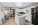 Kitchen boasts white cabinets, tile countertops, and stainless steel appliances at 3228 Rosebud Rd, Loganville, GA 30052