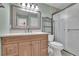 A bathroom featuring wood cabinets, a large mirror and a frosted glass enclosed shower at 411 Berkeley Woods Dr, Duluth, GA 30096