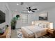 This bedroom has wood floors, a ceiling fan, a bed, nightstands, and two abstract art pieces at 411 Berkeley Woods Dr, Duluth, GA 30096