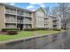 Condominium complex featuring multiple floors and private balconies, surrounded by green landscaping and mature trees at 411 Berkeley Woods Dr, Duluth, GA 30096