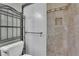 Bathroom featuring a glass-door shower with travertine and decorative tile accents at 411 Berkeley Woods Dr, Duluth, GA 30096