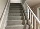 Clean carpeted staircase with white railing at 1485 Reynolds Sw Rd, Atlanta, GA 30331