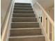 Carpeted staircase with white railings at 1485 Reynolds Sw Rd, Atlanta, GA 30331