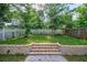 Nicely manicured backyard featuring a stone retaining wall and white and brown wood fencing at 59 Stafford Nw St, Atlanta, GA 30314