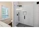 Tiled walk-in shower with glass door and black fixtures, complemented by a window for natural light at 59 Stafford Nw St, Atlanta, GA 30314