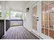 Charming porch with stained wood decking, black railings, white siding, and double doors with glass panes at 59 Stafford Nw St, Atlanta, GA 30314