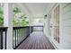 Inviting porch featuring stained wood decking, white siding, black railings, and glass paneled double doors at 59 Stafford Nw St, Atlanta, GA 30314