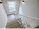 Interior shot of a stairwell featuring gray stairs and white banister with natural light streaming through a window at 59 Stafford Nw St, Atlanta, GA 30314