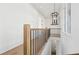 Stunning hallway with hardwood floors, black spindles, and a light fixture at 10861 Serenbe Ln, Chattahoochee Hills, GA 30268