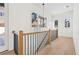 Stunning hallway with hardwood floors, black spindles, and a light fixture at 10861 Serenbe Ln, Chattahoochee Hills, GA 30268