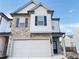 Two-story townhome with stone and white siding, two-car garage, and landscaping at 1394 Ben Park Way, Grayson, GA 30017