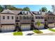 Exterior view of three-story townhomes with brick facade and two-car garages at 705 Dodd N Ln # 163, Buford, GA 30518