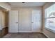 Spacious bedroom with neutral walls, carpet, and double door closet at 113 Omega Ct, Dallas, GA 30157