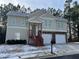 Tan two-story house with a two-car garage and red wooden stairs leading to the front entrance at 113 Omega Ct, Dallas, GA 30157