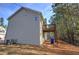 Tan two-story house with red stairs, double garage, and wooded setting at 113 Omega Ct, Dallas, GA 30157