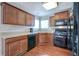 L-shaped kitchen with dark wood cabinets and black appliances at 113 Omega Ct, Dallas, GA 30157