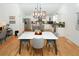 Bright dining room with marble table and hardwood floors, open to kitchen at 4924 River Rd, Ellenwood, GA 30294