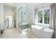 Bathroom featuring a large soaking tub, walk-in shower, and marble tile at 595 Sherwood Ne Rd, Atlanta, GA 30324