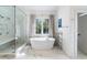 Spa-like bathroom with soaking tub, walk-in shower, and marble flooring at 595 Sherwood Ne Rd, Atlanta, GA 30324