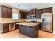 Kitchen with dark wood cabinets, granite island, and stainless steel appliances at 4001 Village Crossing Cir, Ellenwood, GA 30294