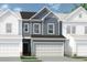 Two-story townhome with gray siding, brown roof, and two-car garage at 1180 Chastain Dr # 9, Sugar Hill, GA 30518