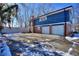 Two-car garage with brick and blue siding on a snowy day at 4593 Bexley Way, Stone Mountain, GA 30083