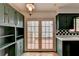 Kitchen with green cabinets, French doors, and terracotta tile floor at 6 Westchester Sq, Decatur, GA 30030