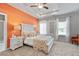 Main bedroom with orange accent wall and ceiling fan at 1182 Chastain Dr # 8, Sugar Hill, GA 30518