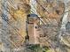 Birds-eye view of a house with a brown roof surrounded by bare trees and a concrete driveway at 3660 Hickory Se Cir, Smyrna, GA 30080