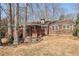Backyard view of a house with a wooden deck, landscaping, and mature trees at 3660 Hickory Se Cir, Smyrna, GA 30080