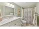 Well-lit bathroom with white vanity, modern fixtures, and a shower with decorative curtain at 3660 Hickory Se Cir, Smyrna, GA 30080