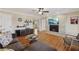 Living room with brick fireplace, TV, hardwood flooring, and modern ceiling fan at 3660 Hickory Se Cir, Smyrna, GA 30080