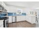 Bright kitchen featuring white cabinets, stainless appliances, and blue subway tile backsplash at 3812 Chalmers Ct, Clarkston, GA 30021