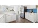 White kitchen with stainless refrigerator and appliances, and blue subway tile backsplash at 3812 Chalmers Ct, Clarkston, GA 30021