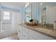 Bathroom boasting double sink vanity with granite counters, decorative mirror, and a tub with shower at 2222 Hill Nw St, Atlanta, GA 30318