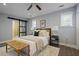 Bedroom featuring hardwood floors, ceiling fan, comfy bed with bench, and a sliding door to the bath at 2222 Hill Nw St, Atlanta, GA 30318