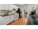 Modern kitchen with white cabinets, granite countertops, and hardwood floors at 3669 White Sands Way, Suwanee, GA 30024