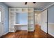 Bedroom featuring hardwood floors, built-in shelving and desk, and partial view to hall at 1995 Benson Se Ave, Smyrna, GA 30080