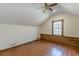 Simple attic bedroom with wood floors and ceiling fan at 5664 Dorsett Shoals Rd, Douglasville, GA 30135