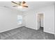 This bedroom features a ceiling fan, access to a walk-in closet, and neutral carpet at 1580 Mary George Nw Ave, Atlanta, GA 30318